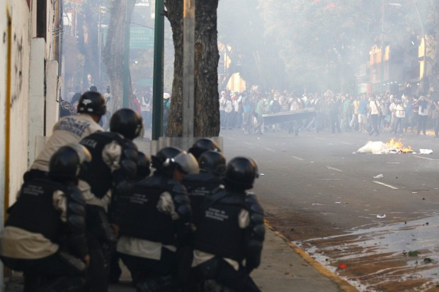 Policiais enfrentam apoiadores de Leopoldo Lopez, opositor do governo de Nicolás Maduro, durante protestos nas ruas de Caracas | Carlos Garcia Rawlins/Reuters