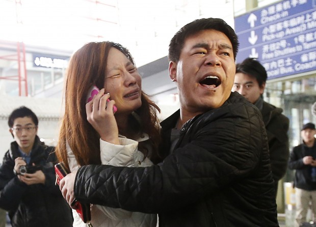 Parente de passageiros do avião desaparecido da Malaysia Airlines chora e fala ao telefone no aeroporto de Pequim, na China | Kim Kyung-Hoon/Reuters