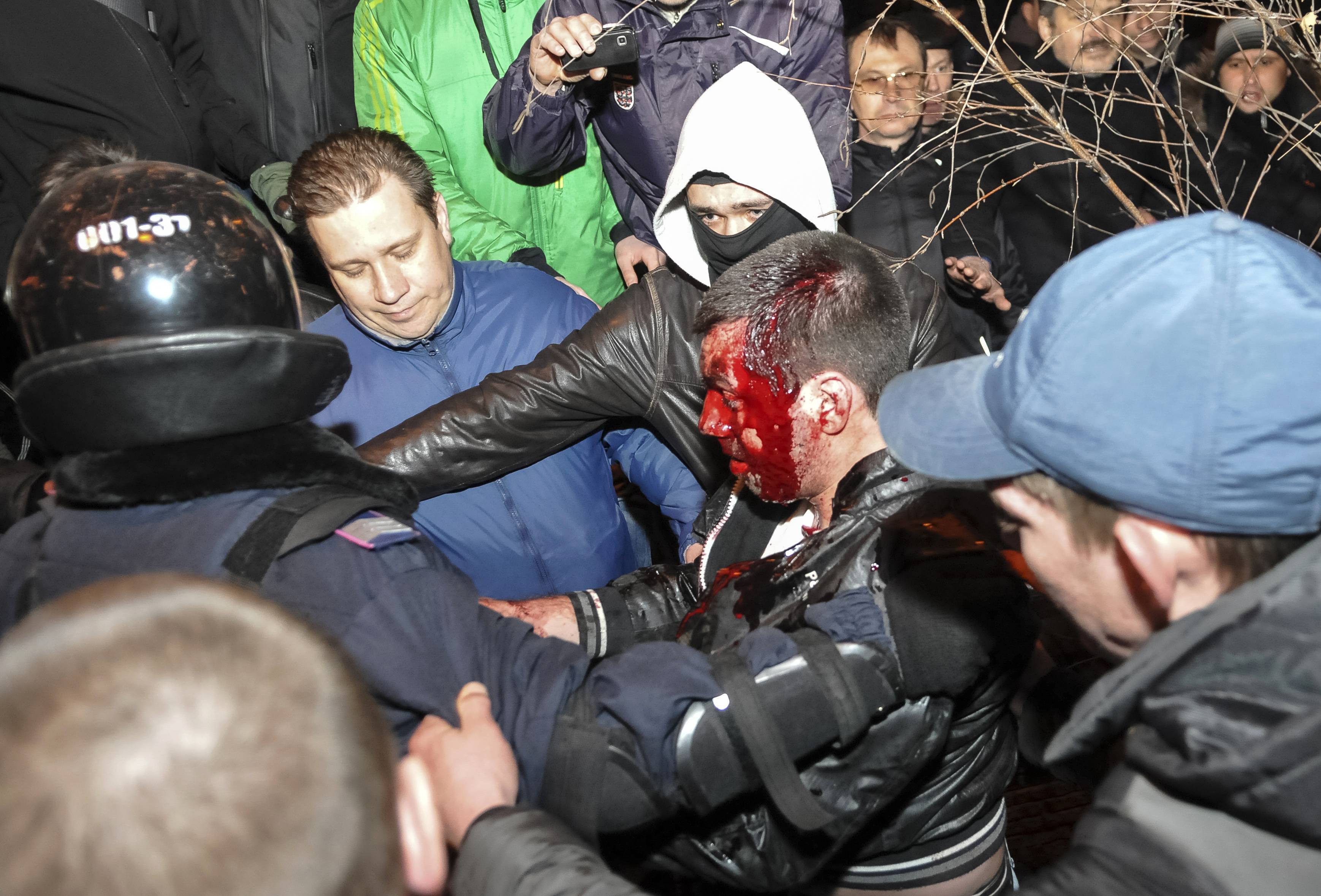 Policiais conduzem manifestante ferido em confronto na cidade ucraniana de Donetsk, onde uma pessoa morreu | Mikhail Maslovsky/Reuters