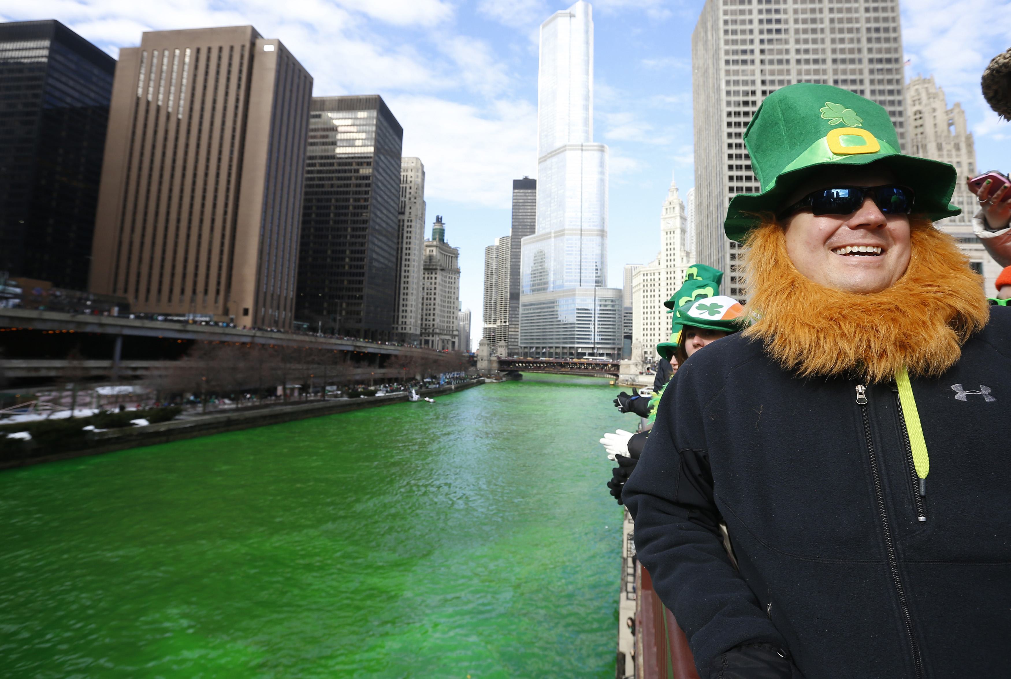 Homem vestido de duende posa para foto perto do rio Chicago, que ganha coloração verde, uma tradição da festa pelo Dia de São Patricio | Jim Young/Reuters