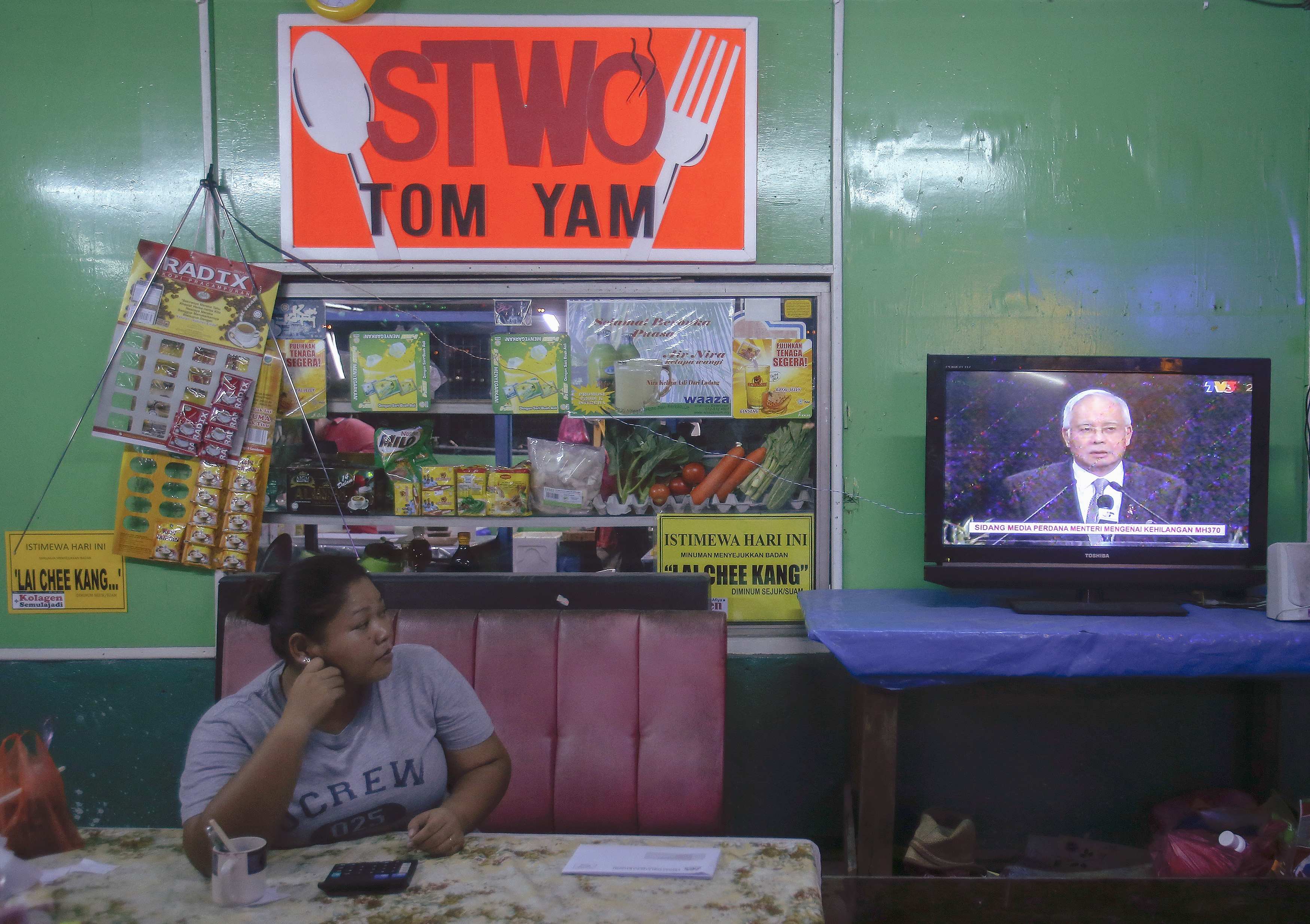 O primeiro-ministro da Malásia Najib Razak é visto na televisão, no momento do anúncio | Samsul Said/ Reuters
