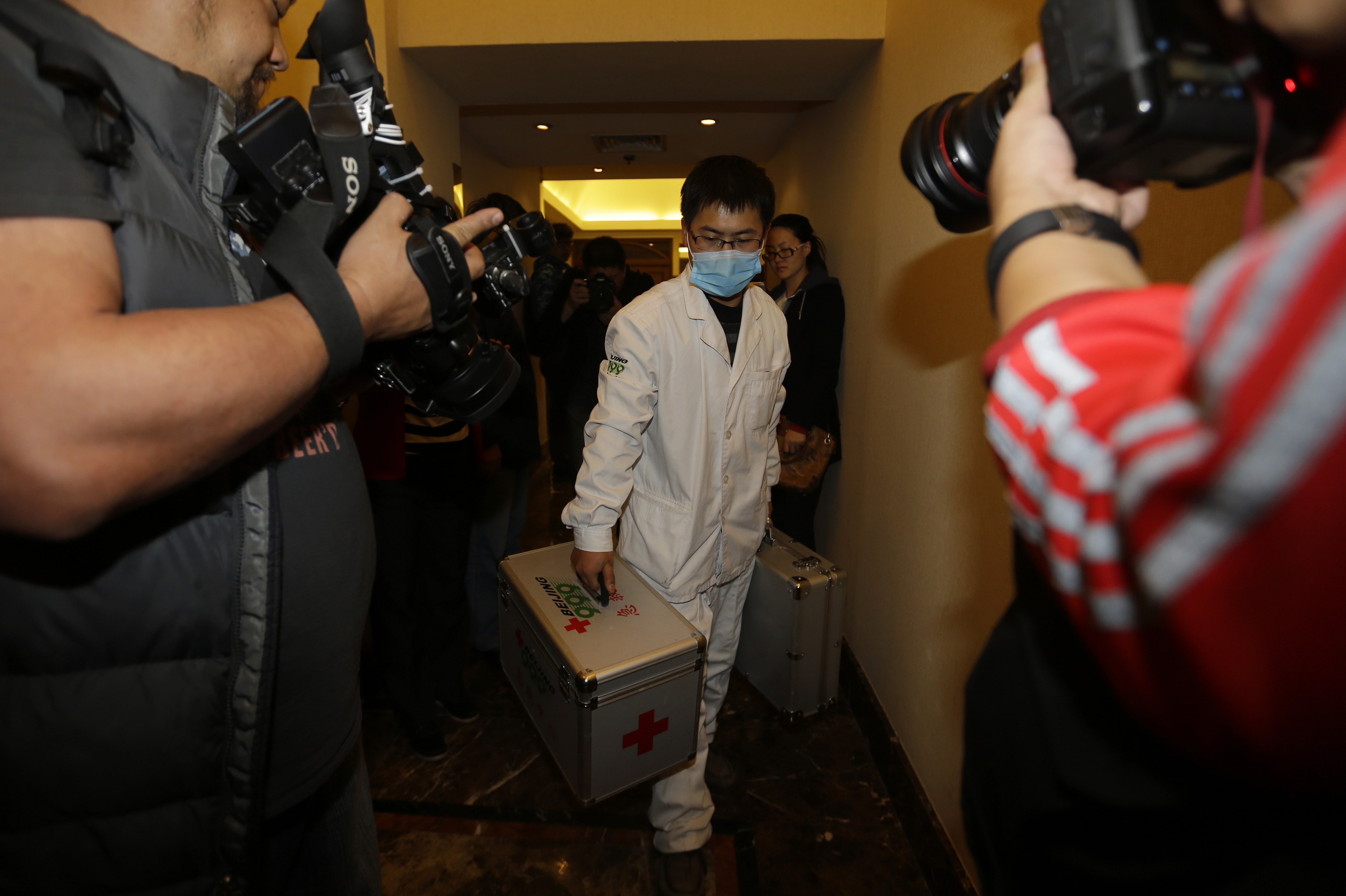 Um enfermeiro carrega um kit de primeiros-socorros enquanto atravessa o corredor do hotel onde estão hospedados os familiares dos passageiros a bordo do Malaysia Airlines MH370, em Beijing | Jason Lee/ Reuters