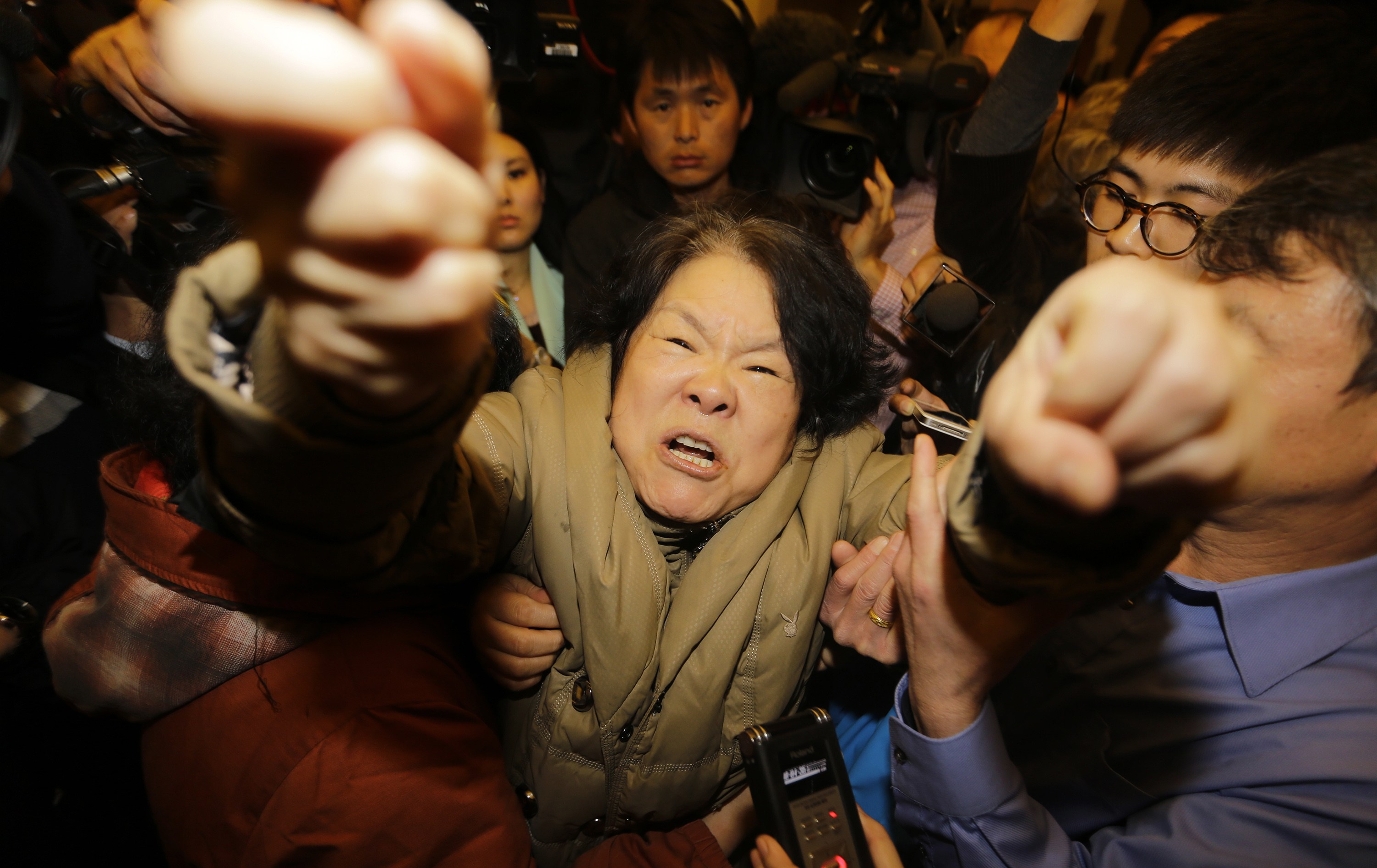 Parente de passageiro do voo grita com jornalistas no hotel em Pequim, onde familiares foram reunidos | Jason Lee/ Reuters