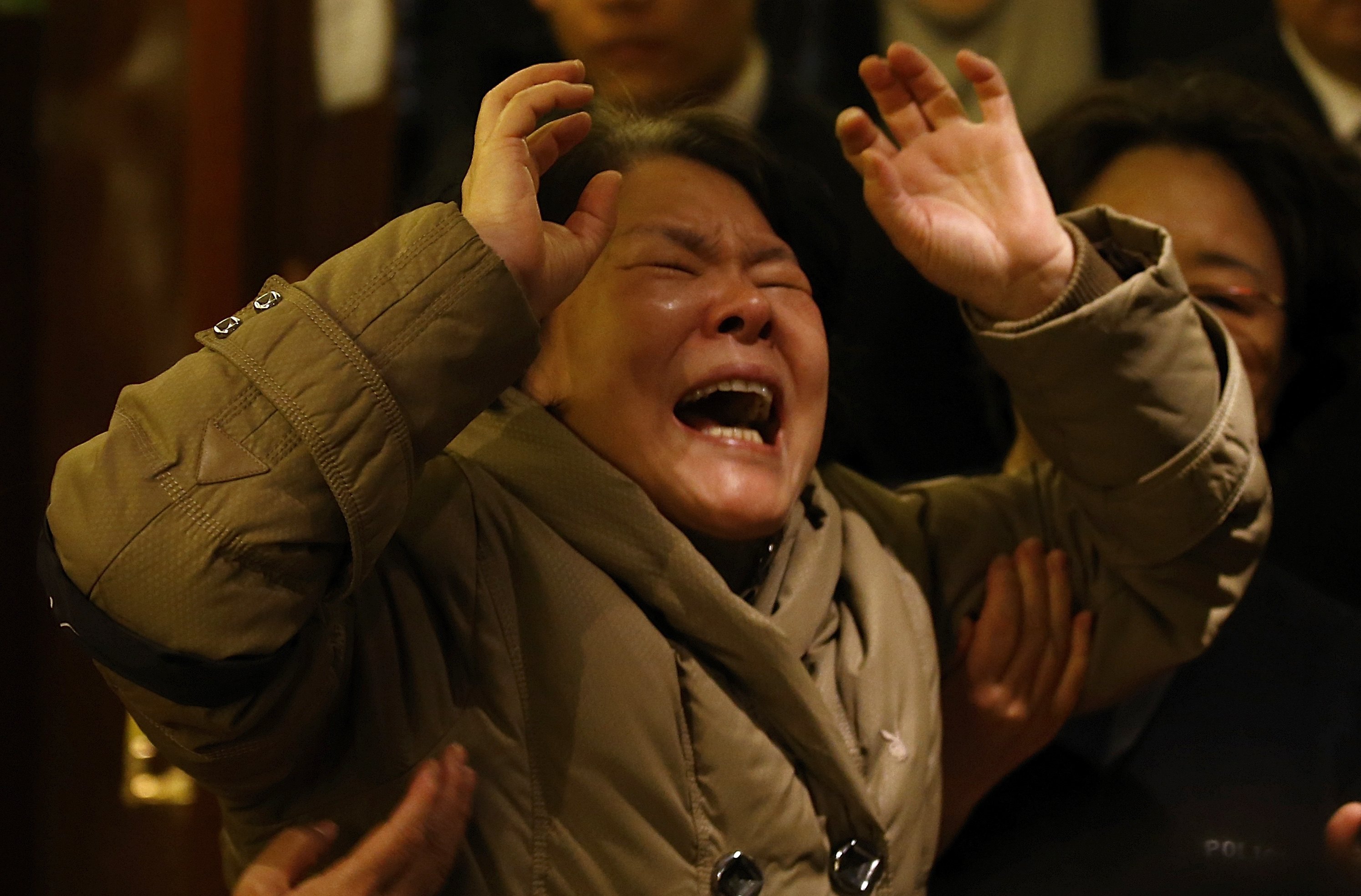 Parente de passageiro que estava a bordo do Malaysia Airlines chora após receber a notícia de que a aeronave caiu no Oceano Índico | Kim Kyung-Hoon/ Reuters