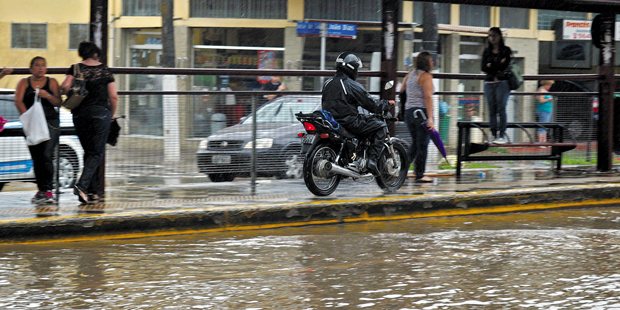 Motociclista foge de alagamento pela calçada da avenida João Dias, na zona sul | Marcelo Alves/Onipress/Folhapress