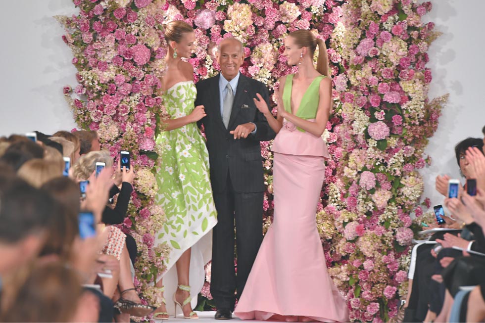 Oscar ao lado de modelos vestindo suas criações, em evento realizado em Nova York no mês passado | Slaven Vlasic/Getty Images